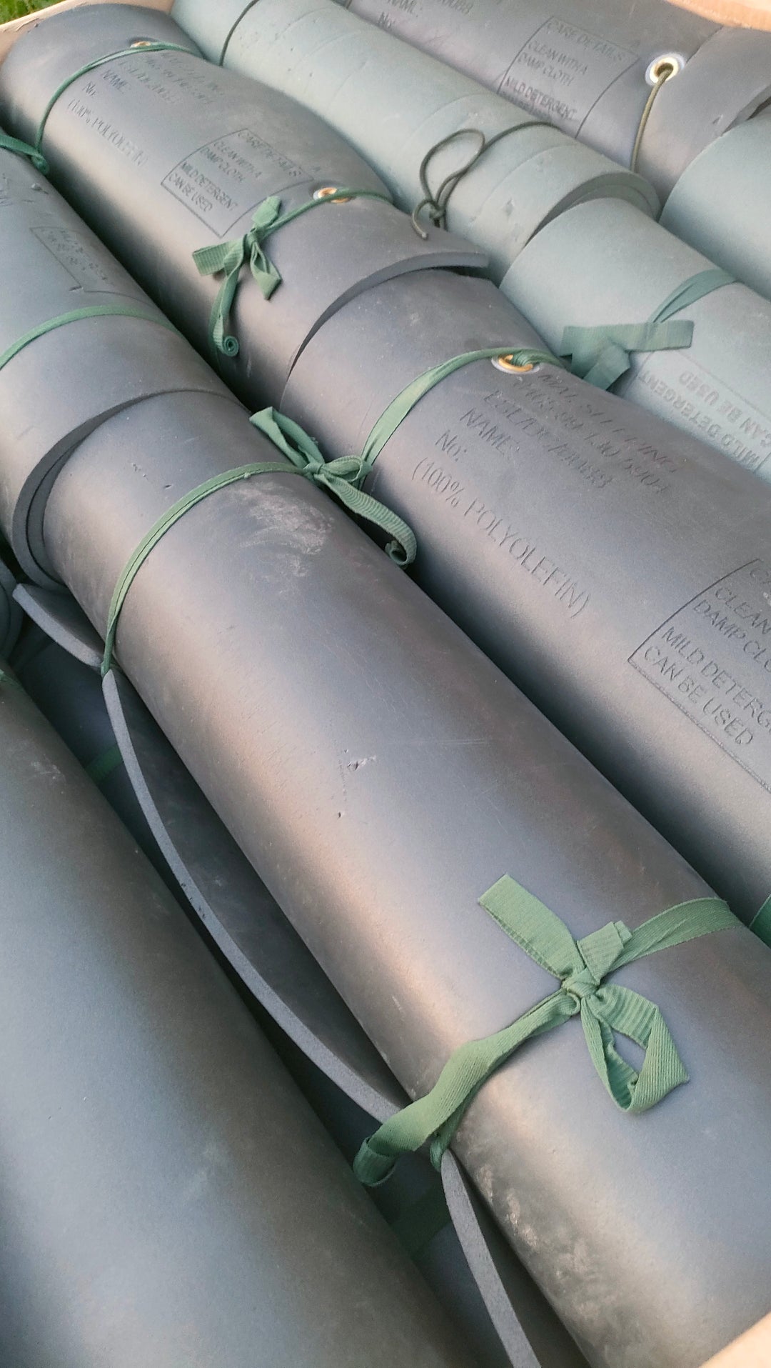 selection of army mats rolled away tied with green straps