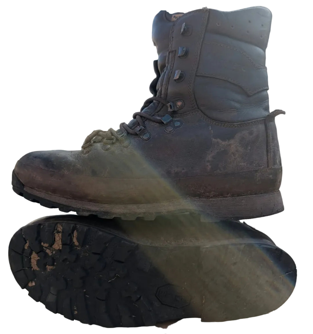 A pair of muddy, dirty tactical combat boots shown from the side and bottom, with one boot resting on top of the other against a white background.
