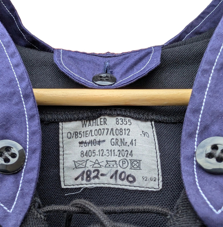 Close-up of a dark gray or black shirt with purple collar and cuffs, featuring a wooden hanger and a visible Waehler size label.