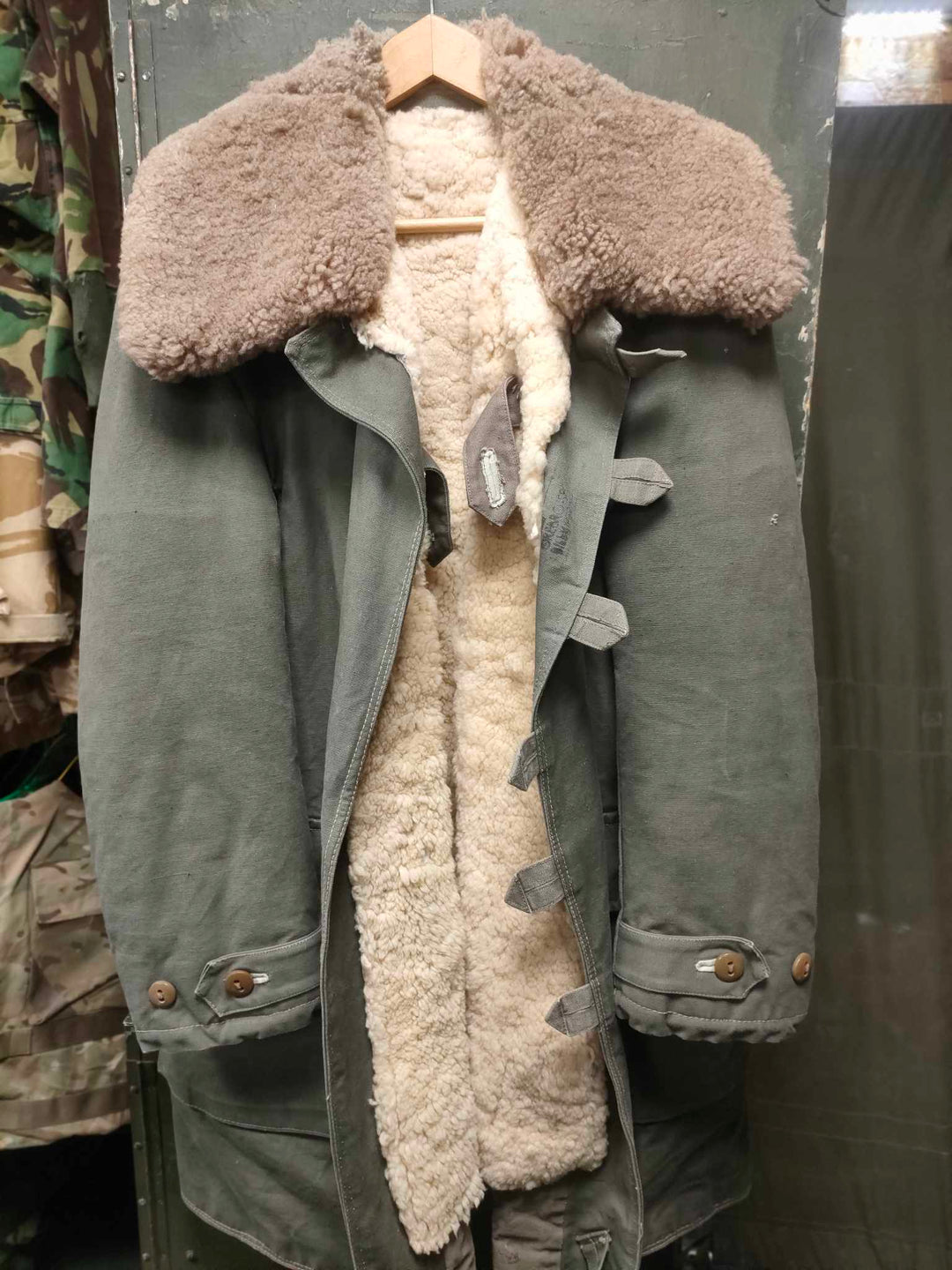 Army green parka with loop button fastenings, brown sheepskin collar and white sheepskin lining