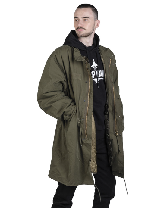 Man wearing a long olive green coat over a black hoodie with visible branding on a white background