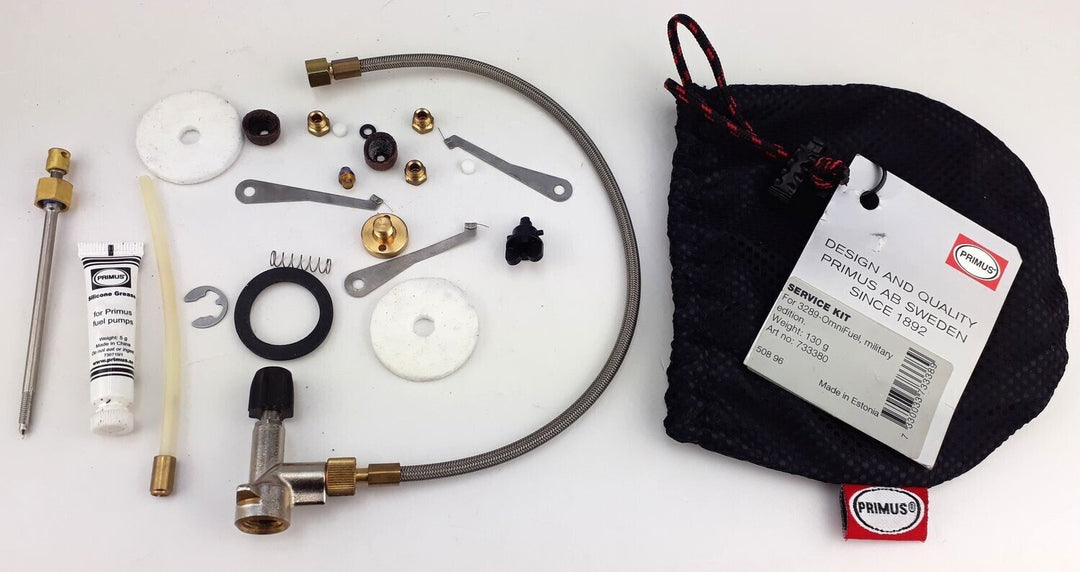 Contents of the kit laid out next to the black mesh pull string bag. includes nuts, spring, tube of silicone grease, valve, tubing, felt spacer and tubing
