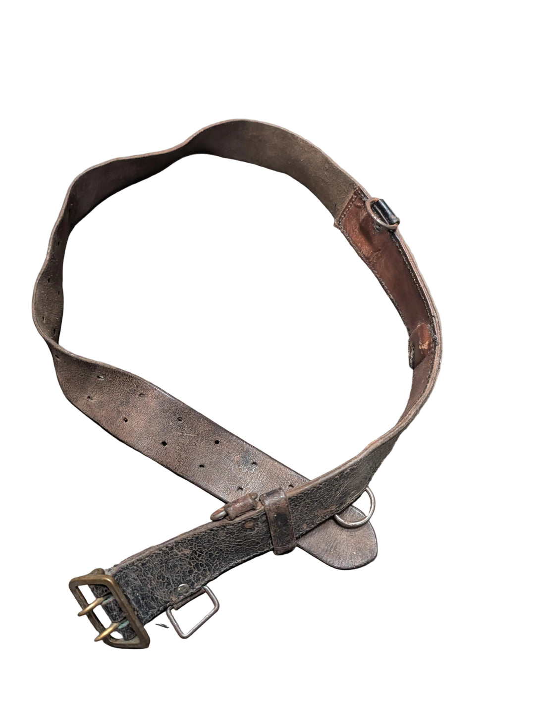 A weathered, dark brown leather belt with a brass buckle, laid out on a gray concrete floor.