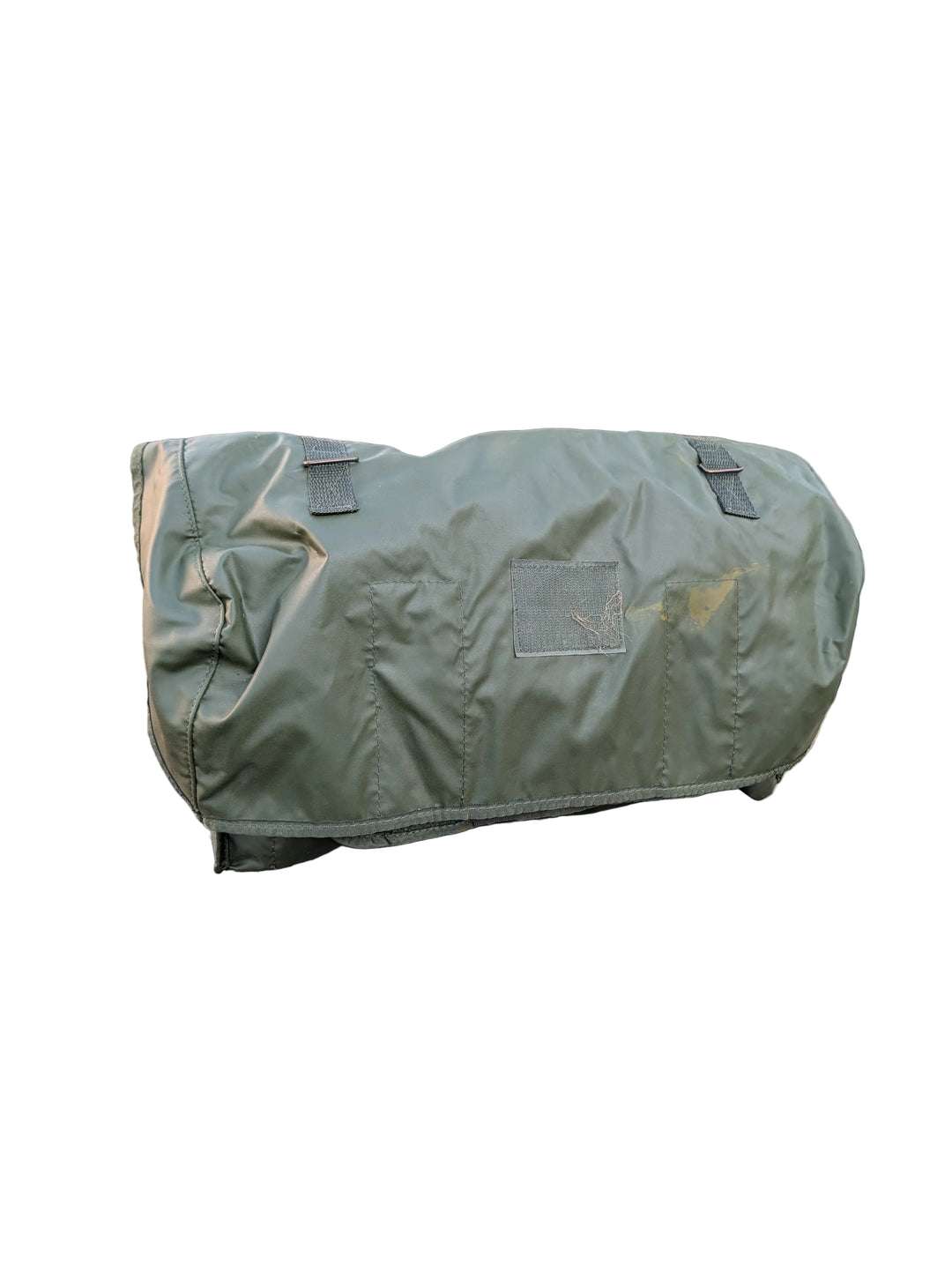 Green military-style duffel bag on a vehicle with a camouflage background