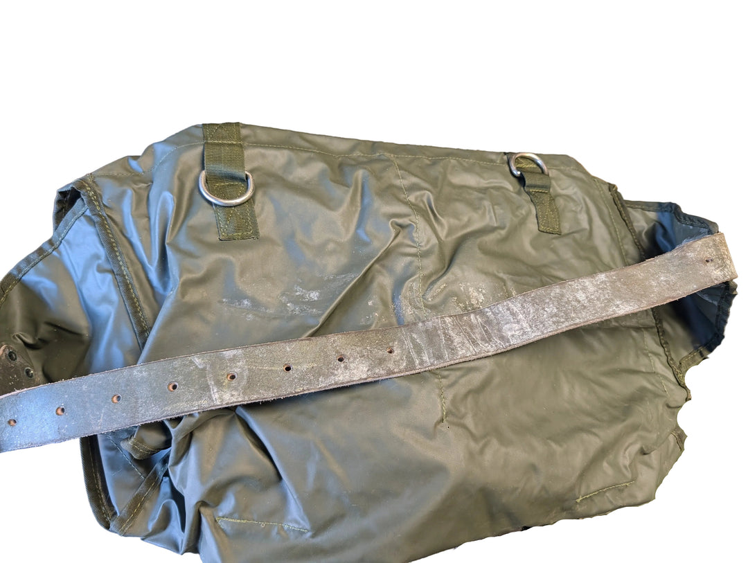 Green military-style duffel bag with a strap on a textured surface