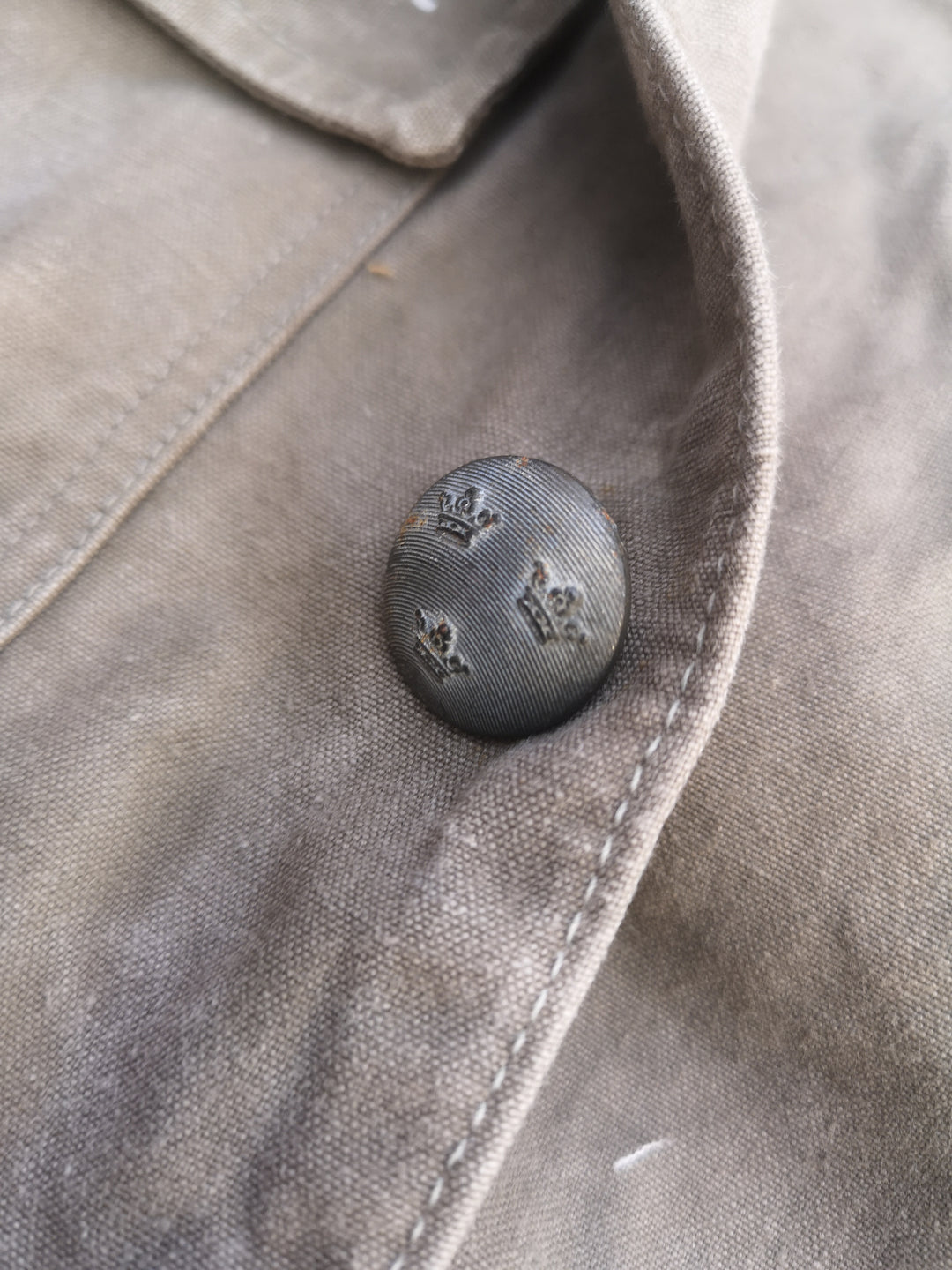 close up shot of fastening button featuring three crowns